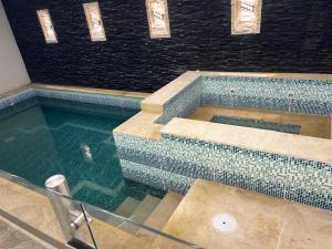 a swimming pool in a building with blue tiles at BLUE DAYS Hotel Melgar in Melgar