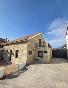 a stone building with a parking lot in front of it at Casa Zoila in Porto do Son