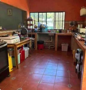 a large kitchen with a tiled floor in a room at Tunco SurfHouse in El Sunzal +5 photos