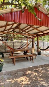 a picnic table with a hammock under a pavilion at Tunco SurfHouse in El Sunzal
