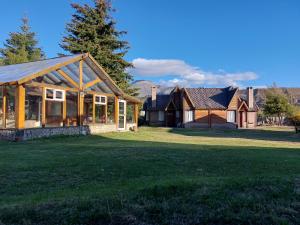 a home with a large yard with a house at Cabañas Mapuche in Esquel