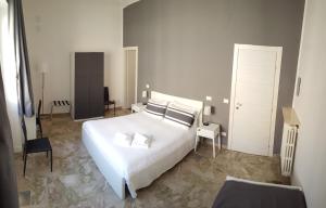 - une chambre avec un grand lit blanc et une chaise dans l'établissement B&B Casa Rosellina, à Palerme