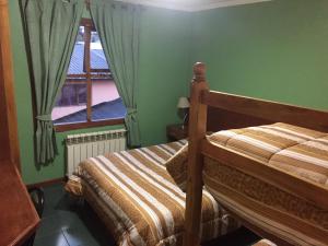a bedroom with a bed and a window at Apart Hotel Alem in Ushuaia