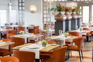 a restaurant with tables and chairs and vases on the wall at SOL by Meliá Barbacan in Playa del Ingles