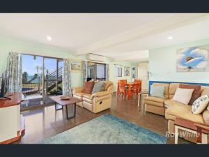 a living room with two couches and a table at Driftwood in Bargara