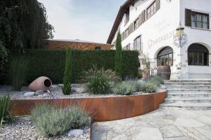 ein Gebäude mit einem Garten mit Pflanzen davor in der Unterkunft Italian Lifestyle Hotel & Osteria Chartreuse in Thun