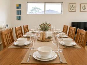 a dining room table with plates and wine glasses at The Coastal Haven in Manyana +26 photos