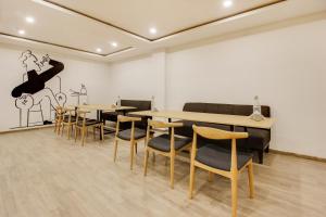 a dining room with tables and chairs and a dancer on the wall at Super townhouse moosapet Rcc Prime in Hyderabad +62 photos