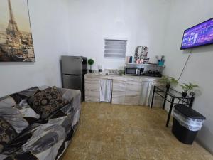 a living room with a couch and a kitchen at Relax en el pueblo 1 in Fajardo