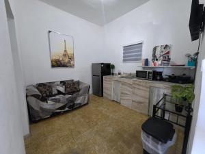a kitchen with a refrigerator and a couch in a room at Relax en el pueblo 1 in Fajardo