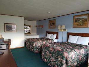 Habitación de hotel con 2 camas y escritorio en A Sapphire Inn, en Franklin