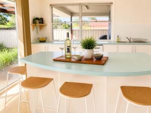 a kitchen with a table with a bottle of wine at The Coastal Haven in Manyana
