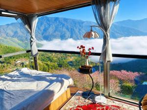 a bedroom with a bed and a view of the mountains at Homestay 26 Cơ Sở 2 Tà Xùa in Bắc Yên
