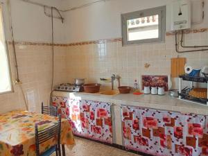 a kitchen with a stove and a counter top at Appartement avec terrasse Vu sur mer in Rebaïb