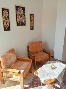 a living room with two chairs and a table at Appartement avec terrasse Vu sur mer in Rebaïb