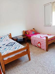 a room with two beds and a couch in it at Appartement avec terrasse Vu sur mer in Rebaïb