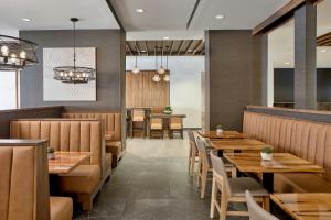 a dining room with wooden tables and chairs at SpringHill Suites by Marriott Moab in Moab