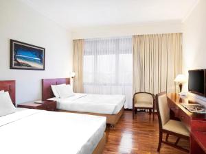 a hotel room with two beds and a desk at MMUGM Hotel in Yogyakarta +19 photos