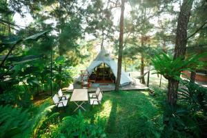 a tent in a garden with chairs and trees at MAHALAYA Garden Resort in Pablengan