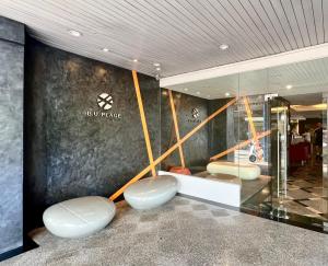 a lobby with two white stools in front of a store at BU Place Hotel in Bangkok