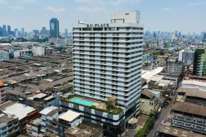 a tall white building with a sign on it in a city at BU Place Hotel in Bangkok