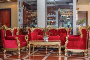 a living room with two red couches and a coffee table at Shkodër Grand Hotel Europa, Affiliated by Meliá in Shkodër