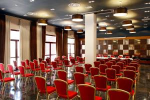 a room with red chairs and tables and windows at voco Madrid - Las Tablas by IHG in Madrid +116 photos