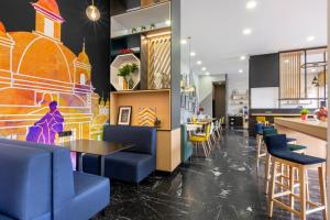 a restaurant with blue chairs and tables and a bar at voco Madrid - Las Tablas by IHG in Madrid