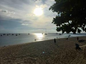 a group of people on a beach with boats in the water at Tonys homestay in Zanzibar City