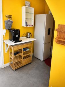 a kitchen with a white refrigerator and a table with a microwave at An Dorzell beach 60 meters in Cléder