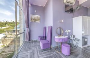 a purple room with a mirror and purple stools at Mac Valley DaLat Hotel in Da Lat