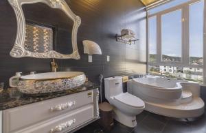 a bathroom with a tub and a sink and a toilet at Mac Valley DaLat Hotel in Da Lat +61 photos