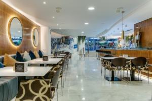 a restaurant with tables and chairs in a room at Sercotel Caspe in Barcelona