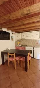 a kitchen with a black table and chairs in it at Nespello Tourist Accommodation in Costa di Serina