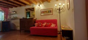 a living room with a red chair with stuffed animals on it at Nespello Tourist Accommodation in Costa di Serina
