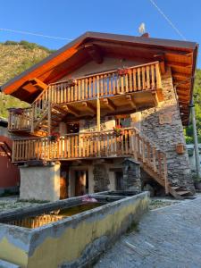 a building with a deck on the side of it at La Meizun de Charles in Salza di Pinerolo