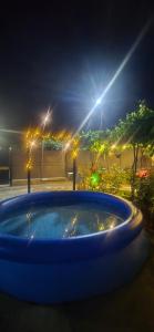 a large blue tub with lights in a park at night at Guesthouse Turo in Ambrolauri