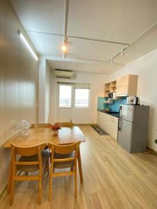 a room with a wooden table and a kitchen at Da nang seaview MT apartment in Danang