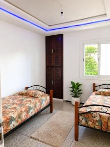 two beds in a room with a window at Perfect home in Temara