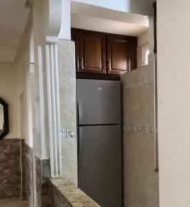 a kitchen with a refrigerator and wooden cabinets at Perfect home in Temara
