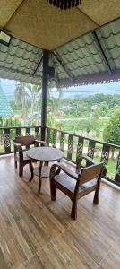 a patio with a table and benches on a wooden floor at ปายเรือนไทย in Pai +9 photos