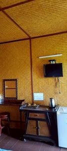 a room with a table and a television in a room with a wall at ปายเรือนไทย in Pai