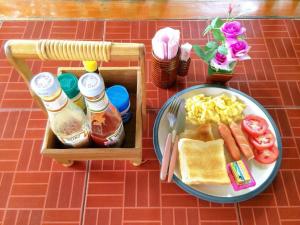 a table with a plate of food and a lunch box at ปายเรือนไทย in Pai