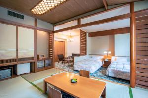 a bedroom with a bed and a table in a room at Choyo Tei in Kamikawa