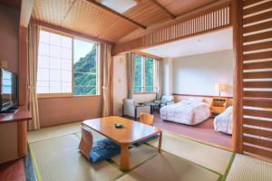 a bedroom with a bed and a table in a room at Choyo Tei in Kamikawa