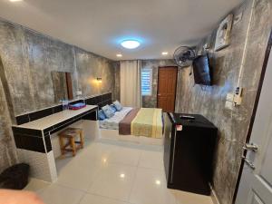 a bathroom with a bed and a sink in a room at BB GuestHouse in Ban Zong Katiam