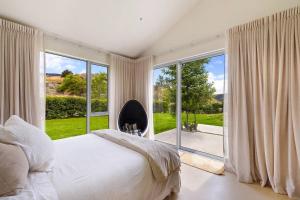a bedroom with a bed and a large window at Pavilion-Style Residence Queenstown in Queenstown