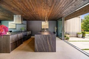 a kitchen with a wooden ceiling and a counter at Pavilion-Style Residence Queenstown in Queenstown +31 photos