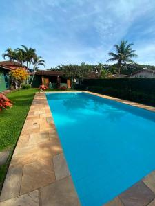 a swimming pool with blue water in a yard at Pousada 4 Elementos Guaruja in Guarujá