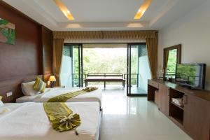 a hotel room with two beds and a television at Samui Honey Tara Villa Residence in Choeng Mon Beach